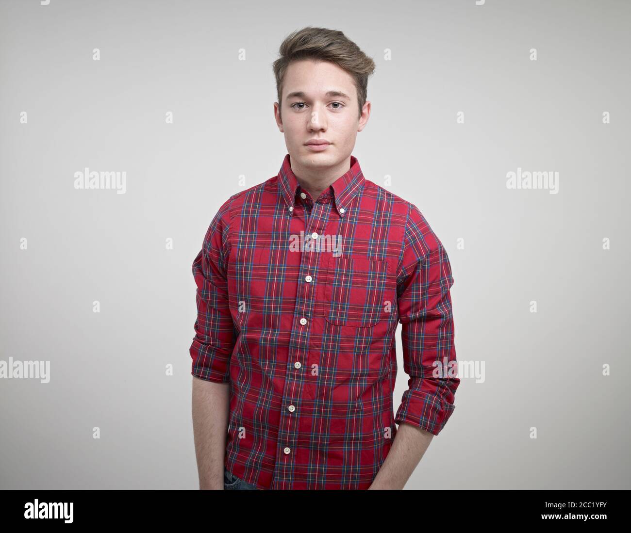 Portrait of young man standing against white background Stock Photo - Alamy