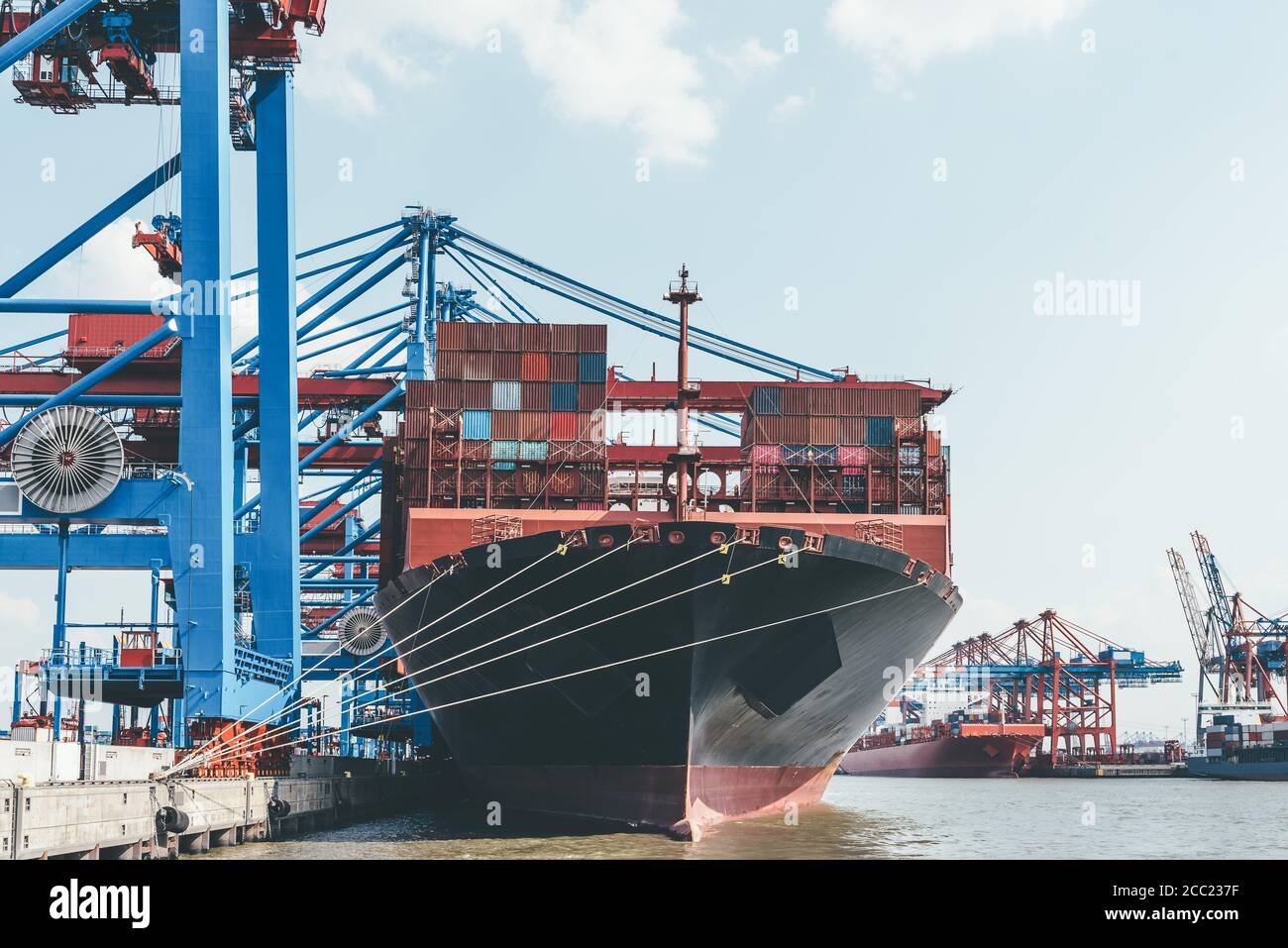 large container ship under container gantry cranes in harbor, transport and trade concept Stock Photo
