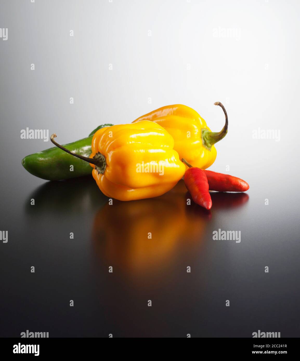 Habaneros and chilis on coloured background, close up Stock Photo