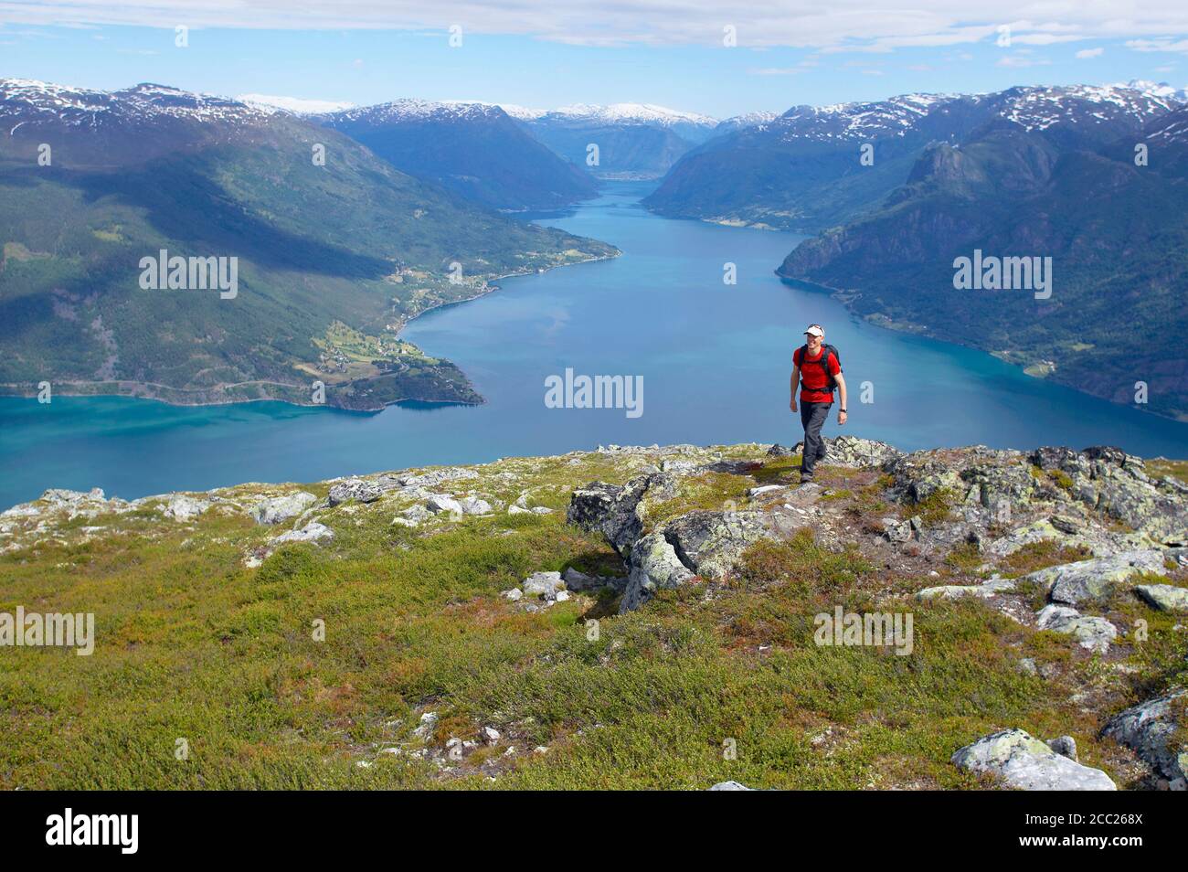 Norway, Lustrafjord, Man hiking across cliff line Stock Photo