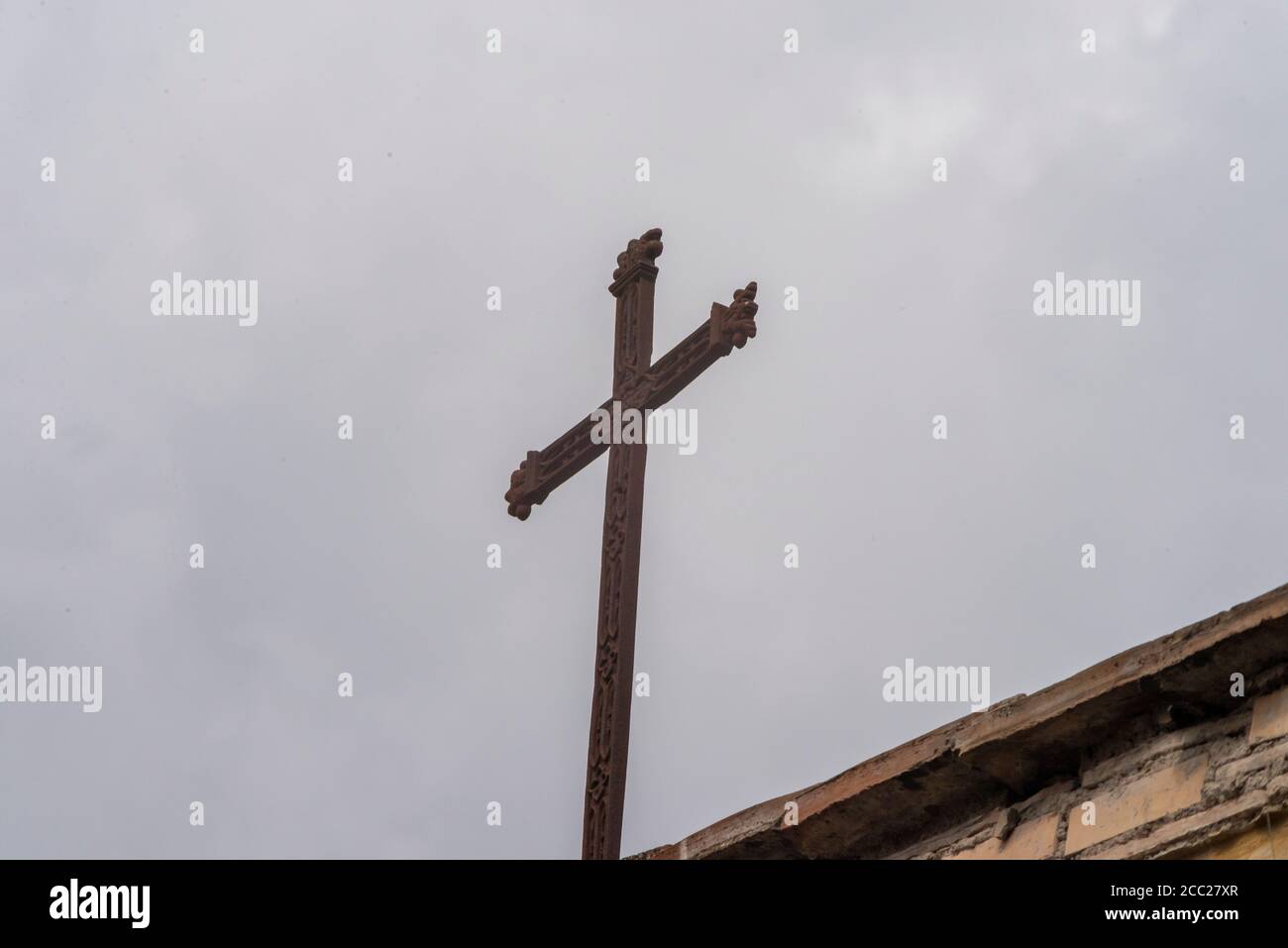 cross placed on the tip of a church roof with gray sky background Stock ...