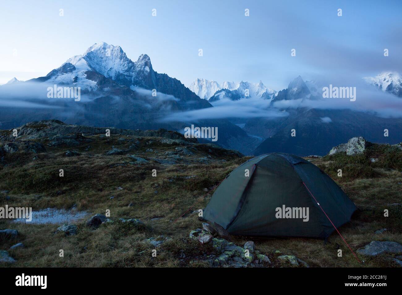 Green tent in the mountains during a colorful sunset. Night bivouac,  million star hotel under night sky, tent on pass in Alps. Camping in the  mountain Stock Photo - Alamy