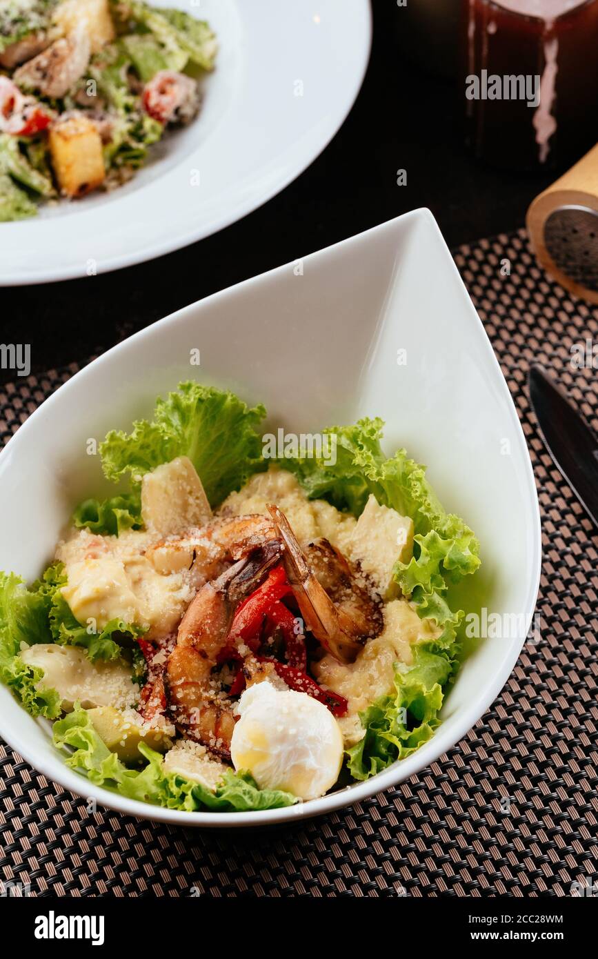 Caesar salad with shrimp on a white plate Stock Photo