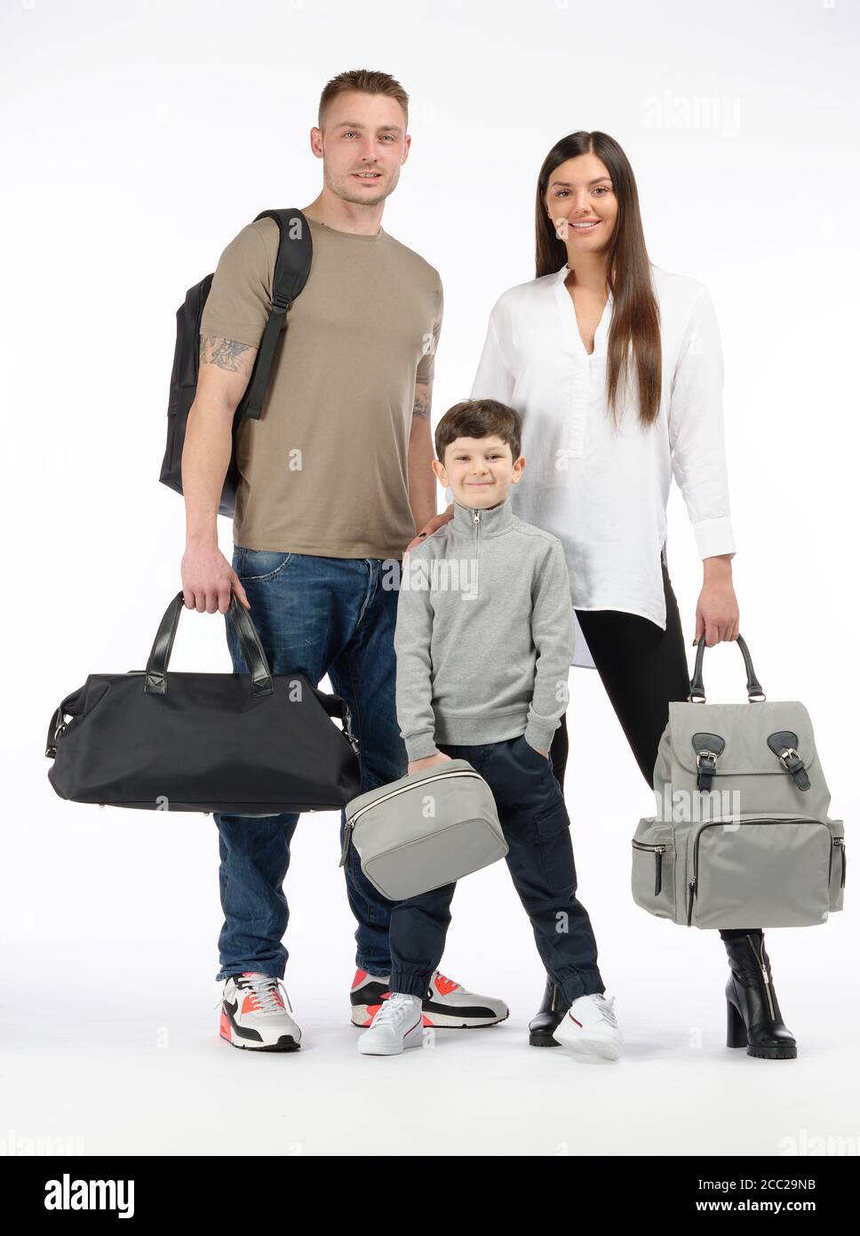 Man, woman and child with bags against a white background Stock Photo ...