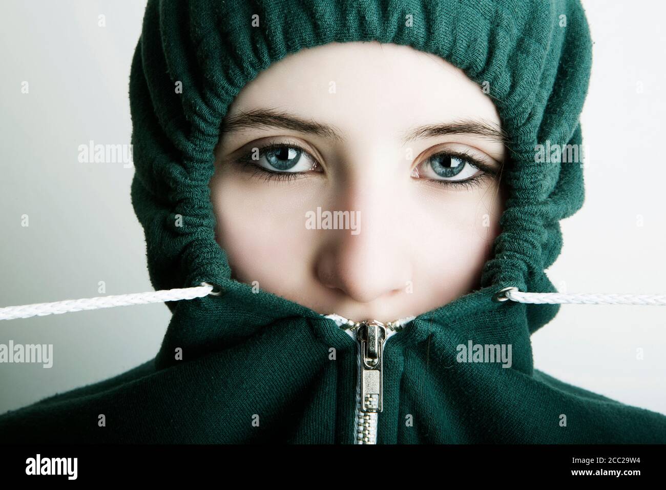 Germany, Cologne, Portrait of teenage girl wearing hooded top, close up Stock Photo