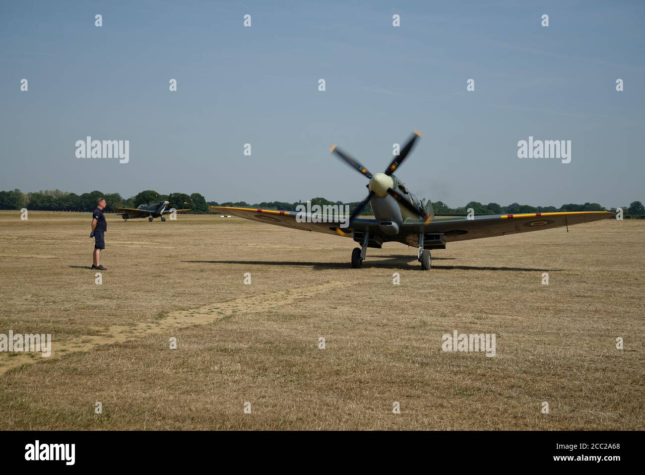 A pair of Spitfire fighter planes at Headcorn airfield in Kent. Taxiing after landing. Stock Photo