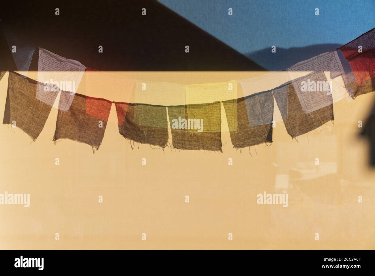 Sun casts shadows of traditional Buddhist prayer flags on a wind screen Stock Photo