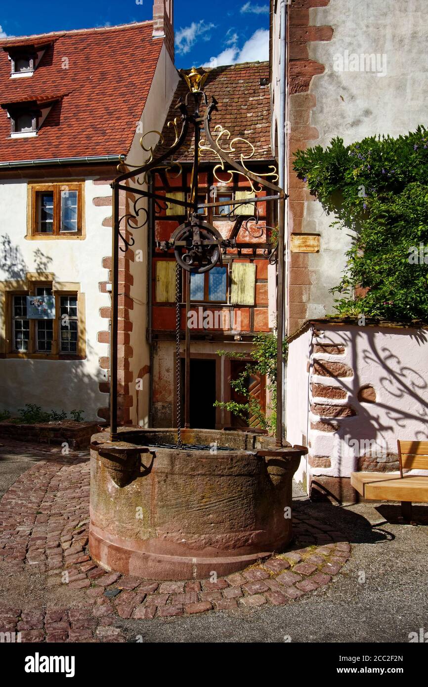 old water well, stone base, wrought iron top, Plas des 3 Eglises, courtyard, buildings, Alsace, Europe, Riquewihr; France Stock Photo