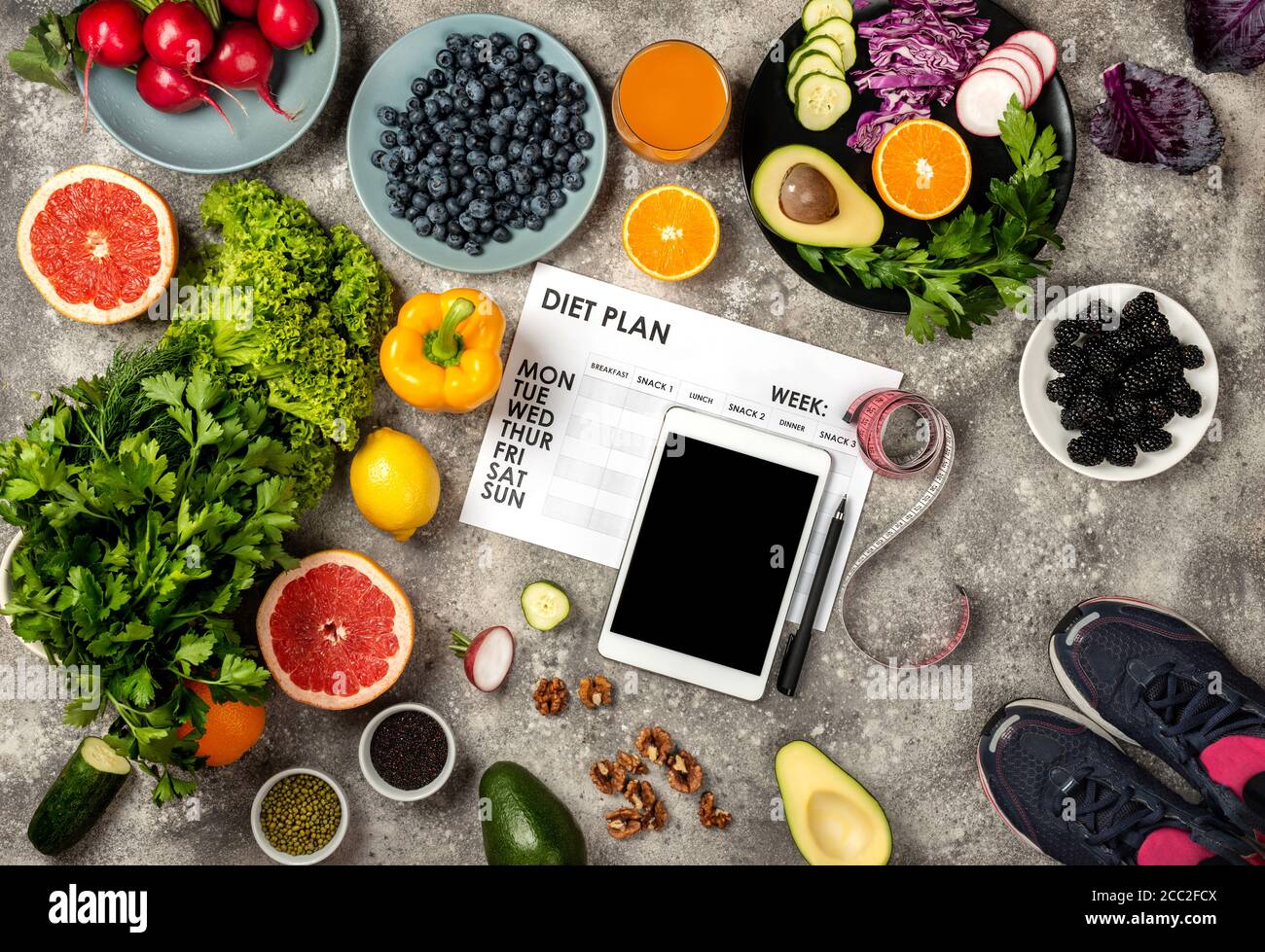 Healthy diet sport lifestyle concept. Weight loss plan Tablet computer Fitness equipment and Fresh food. Top view Stock Photo