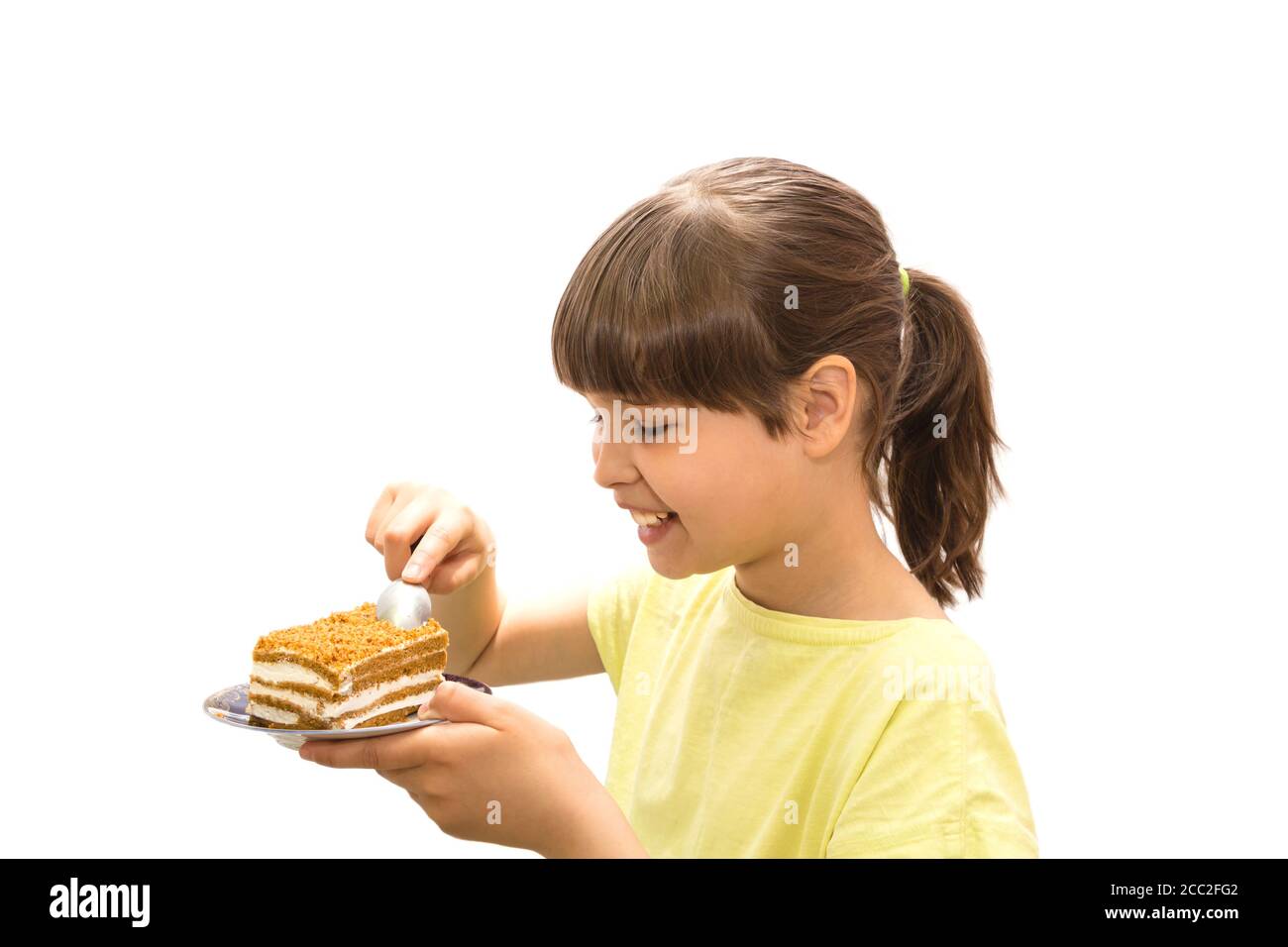 Girl eating cake. Isolated on white background. Stock Photo
