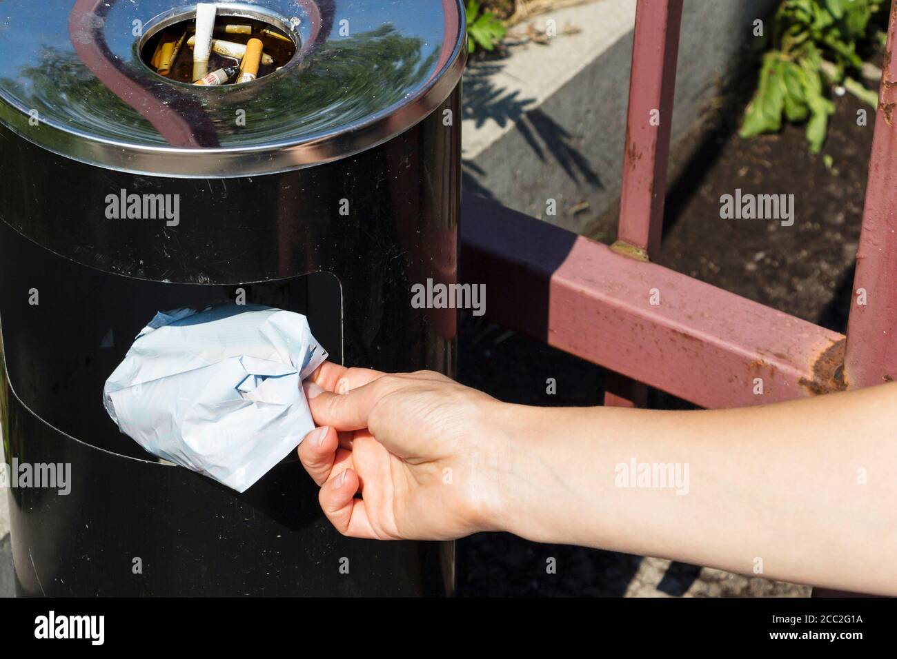 Close up of cropped portrait of someone throwing trash in the trash