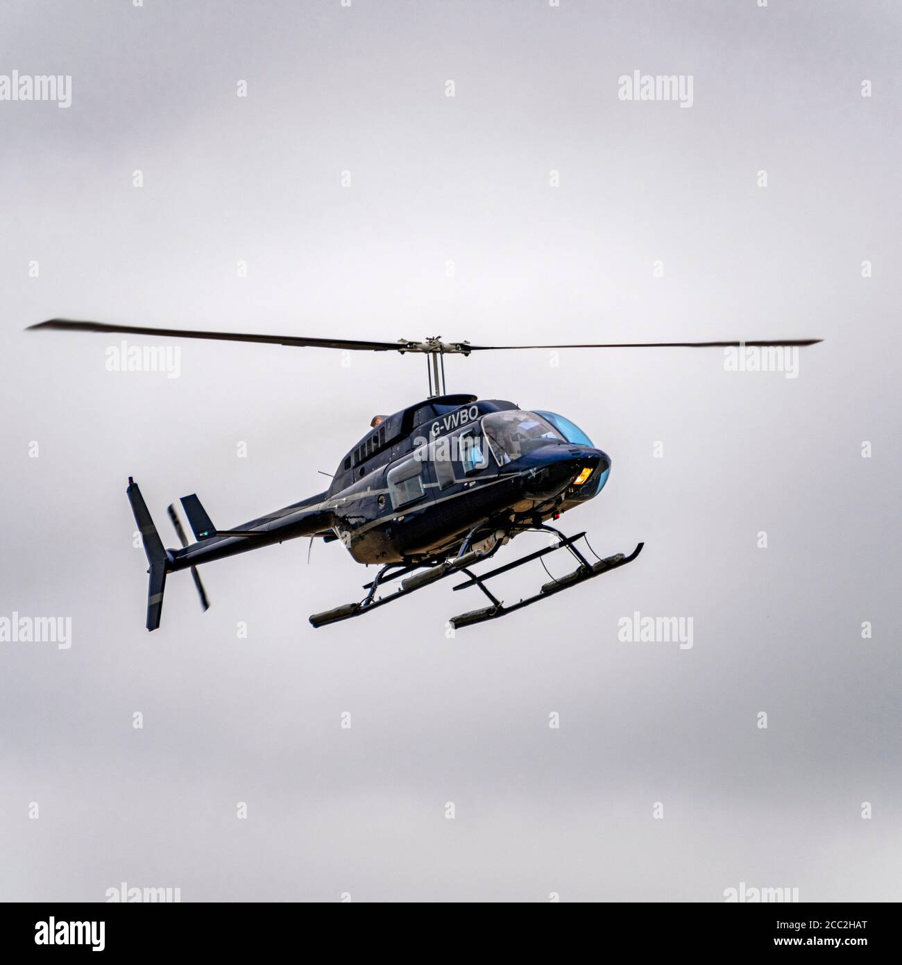 Square close up of a Bell 206 helicopter coming into land. Stock Photo