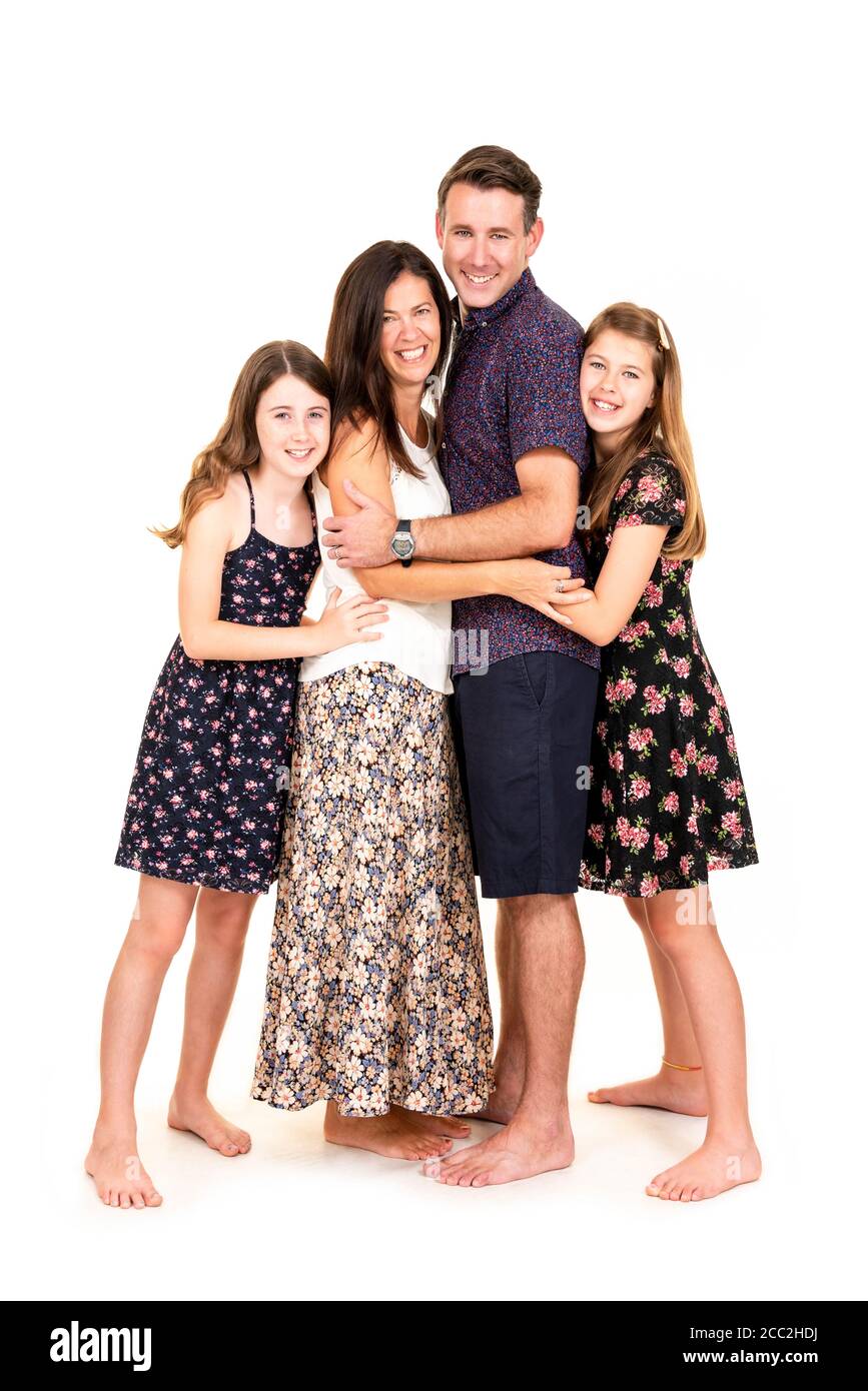 Vertical portrait of a young family against a white background in a studio or high key. Stock Photo