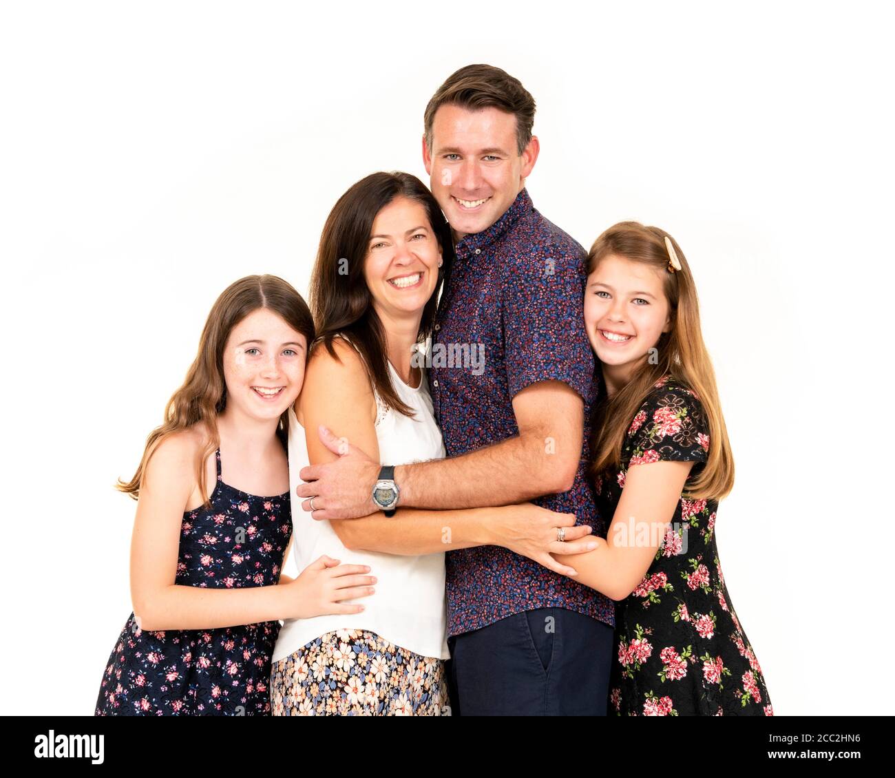 Horizontal portrait of a young family against a white background in a studio or high key. Stock Photo