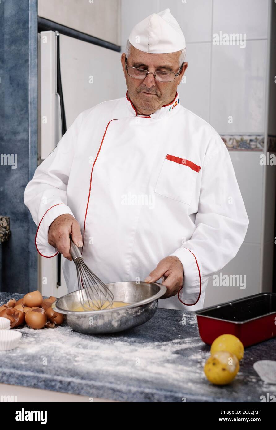 baker mixing eggs with a hand blender Stock Photo - Alamy