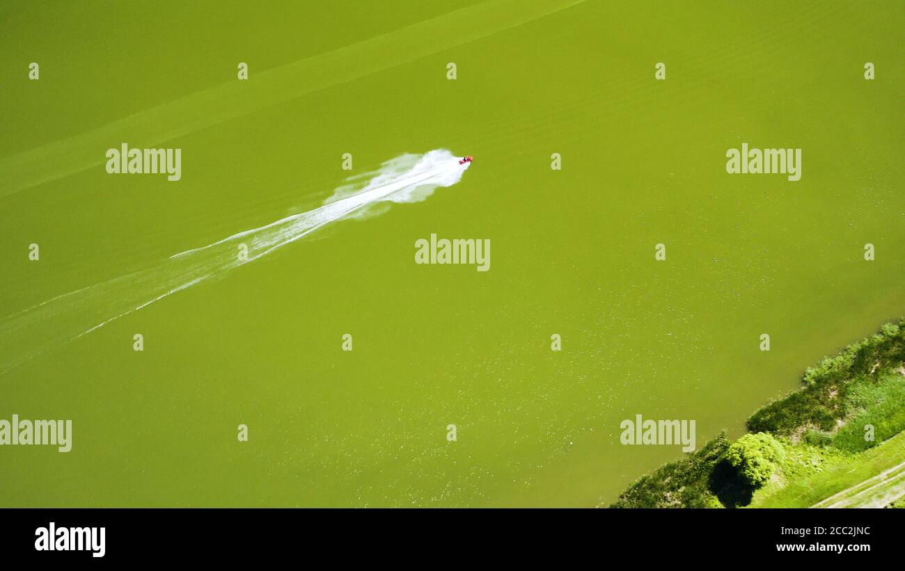 Birds eye shot of a red motorboat riding on a river Stock Photo - Alamy