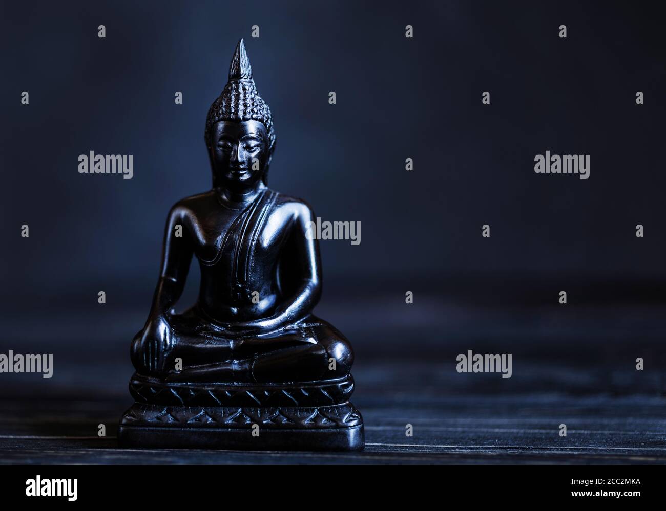 Symbol of Buddhism. Antique Buddha Shakyamuni on a dark background. Calmness concept. Copy space. Stock Photo