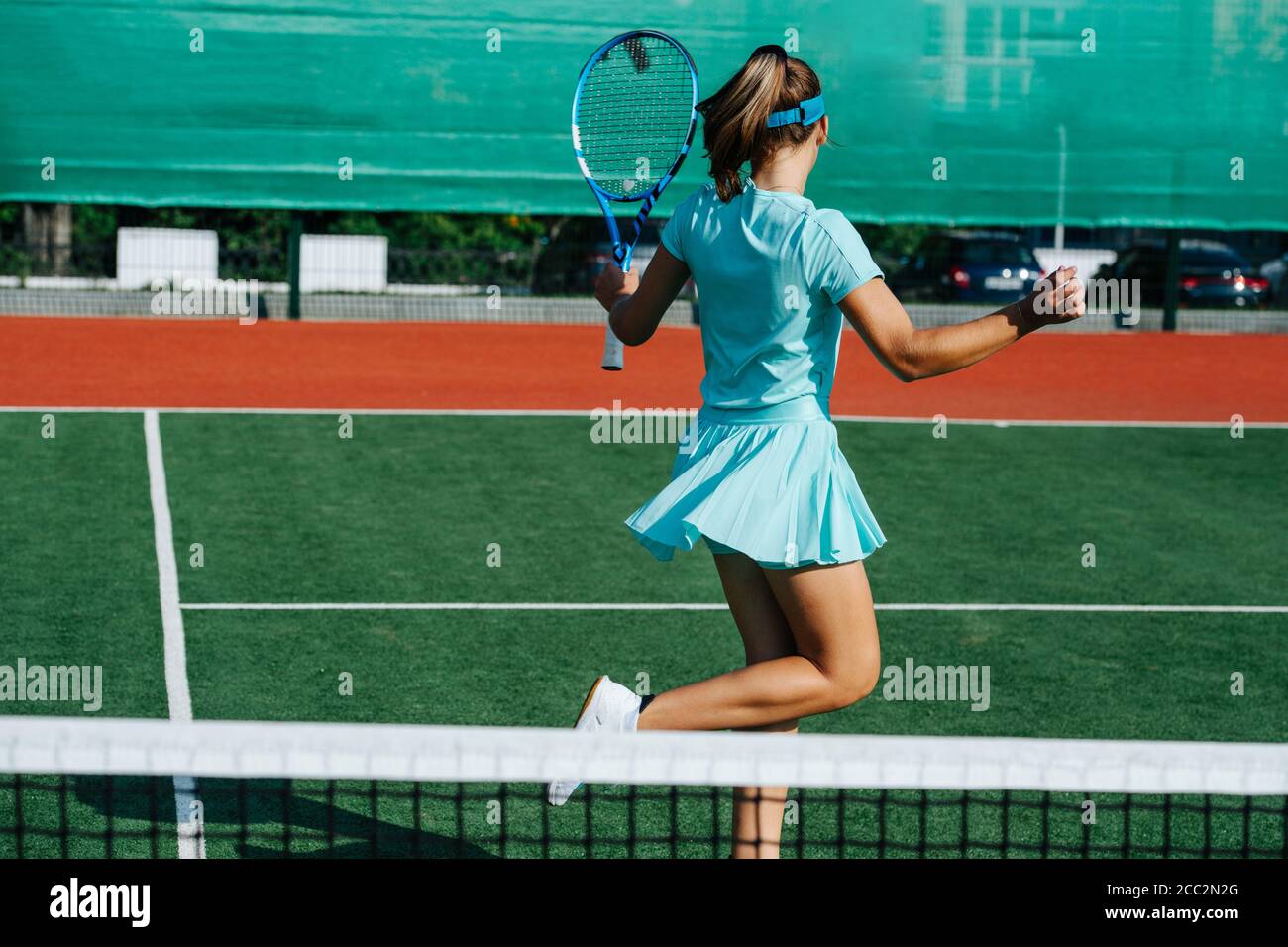 Carefree girl messing around, dancing on tennis court, taking a break Stock Photo