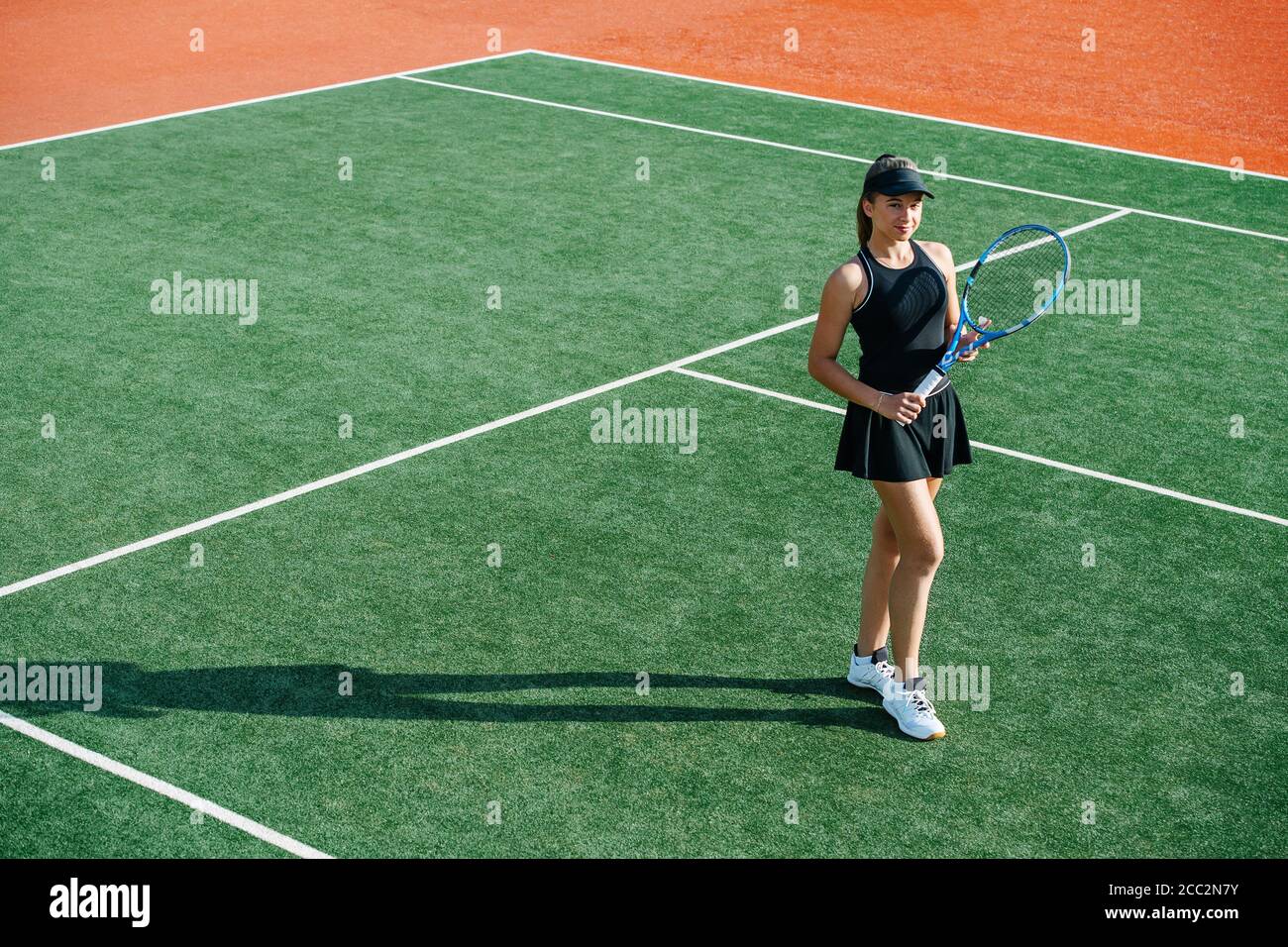 Sixting year old girl smiling in the middle of a brand new tennis court. Stock Photo