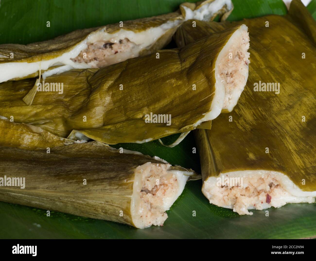 Indian sweet made of steamed rice flour filled with jaggery, cardamom and coconut. Wrapped in turmeric leaves and steam cooked in large vessel. Stock Photo