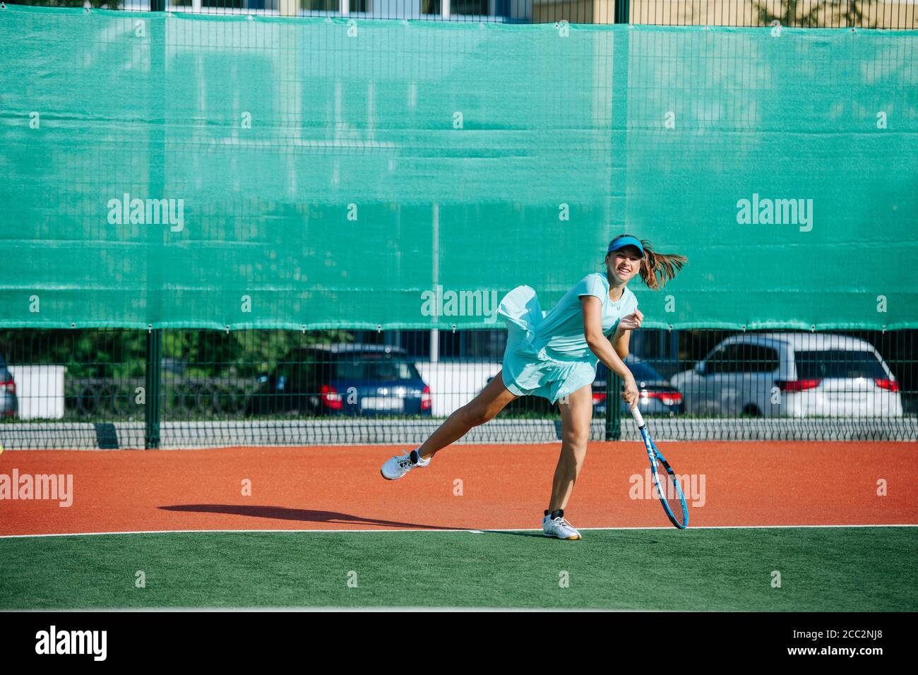 Powerful strike of a teenage girl training on a new tennis court Stock Photo