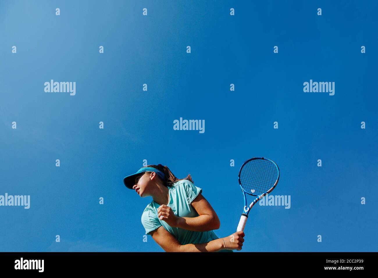 Low angle photo of girl playing tennis, holding racket backhand Stock Photo