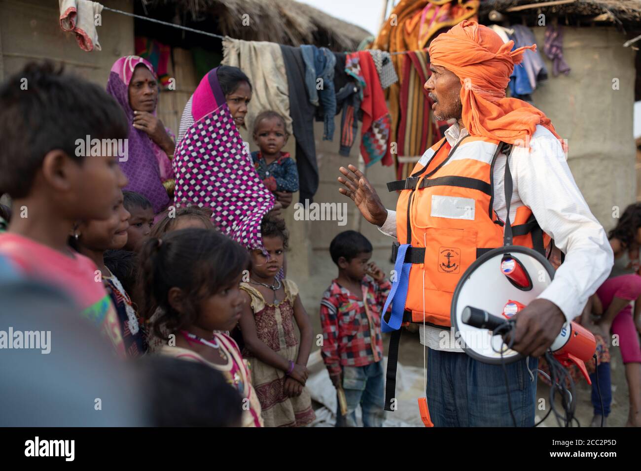 As a member of an Early Warning System task force broadcasts the alarm of an impending flood of the nearby Gandak River to his fellow community members. Stock Photo