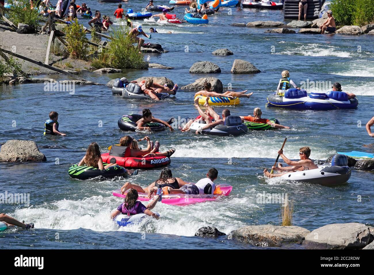 Tourists utilizing the Deschutes River in Bend, Oregon, during the summer. The river is a popular spot for rafters, floaters, paddleboarding, and kaya Stock Photo