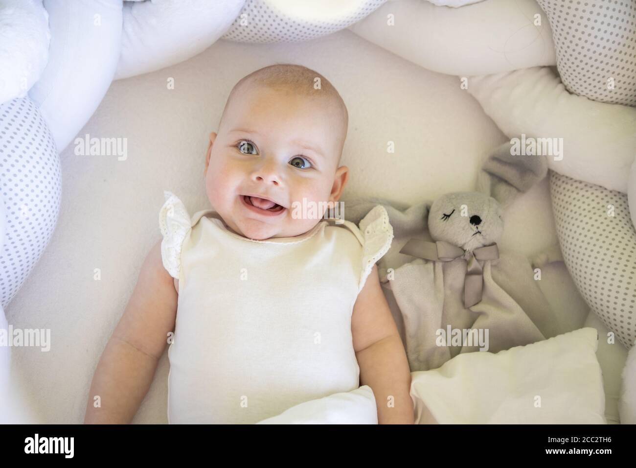 Baby girl lying in cot hi-res stock photography and images - Alamy