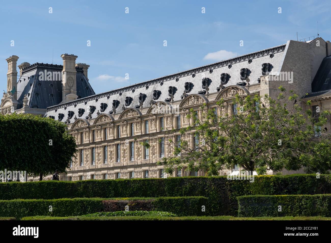 Close-up of Louvre palace museum with park, lawn and flowers at hot sunny day. Jardin des tuileries. Paris - France, 31. may 2019 Stock Photo