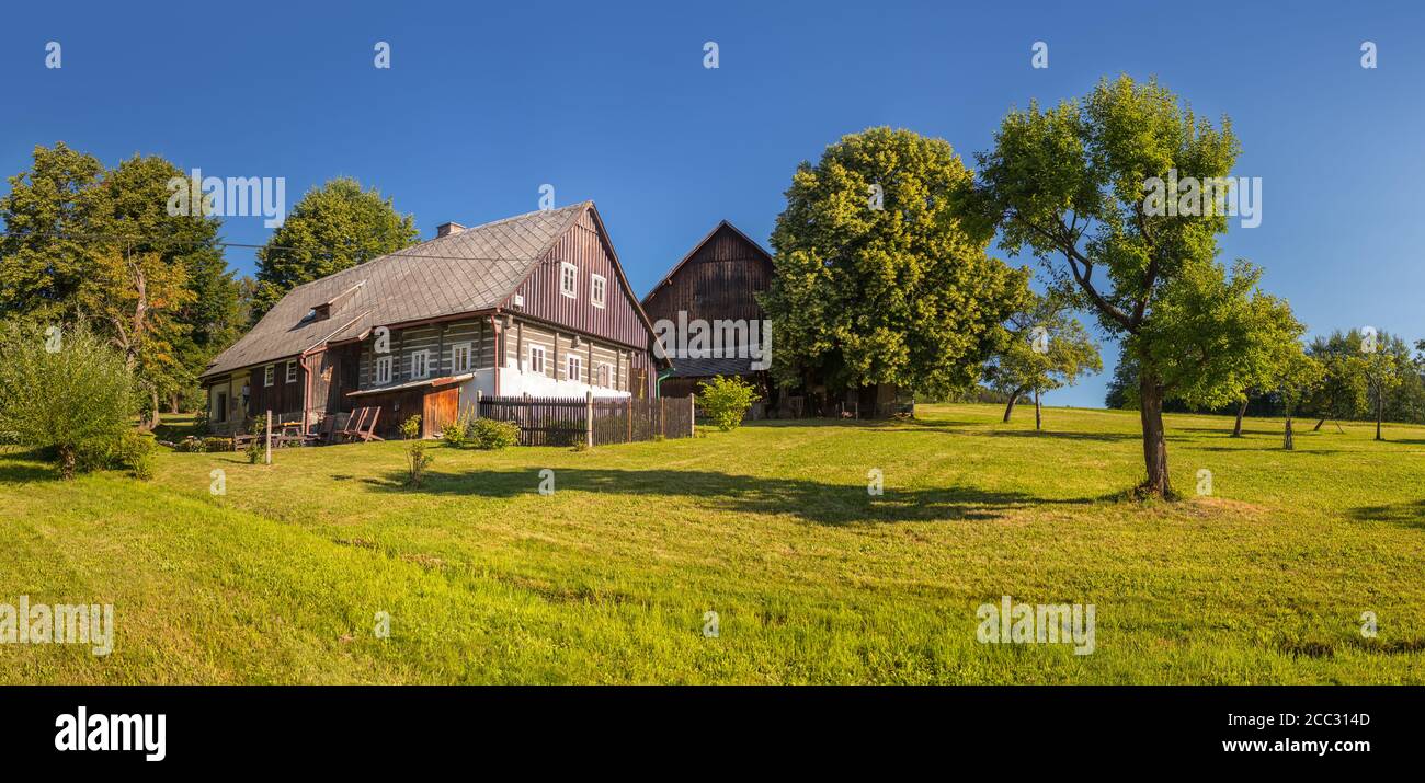 timbered cottage - czech traditional wooden timbered house with trees nearby Stock Photo