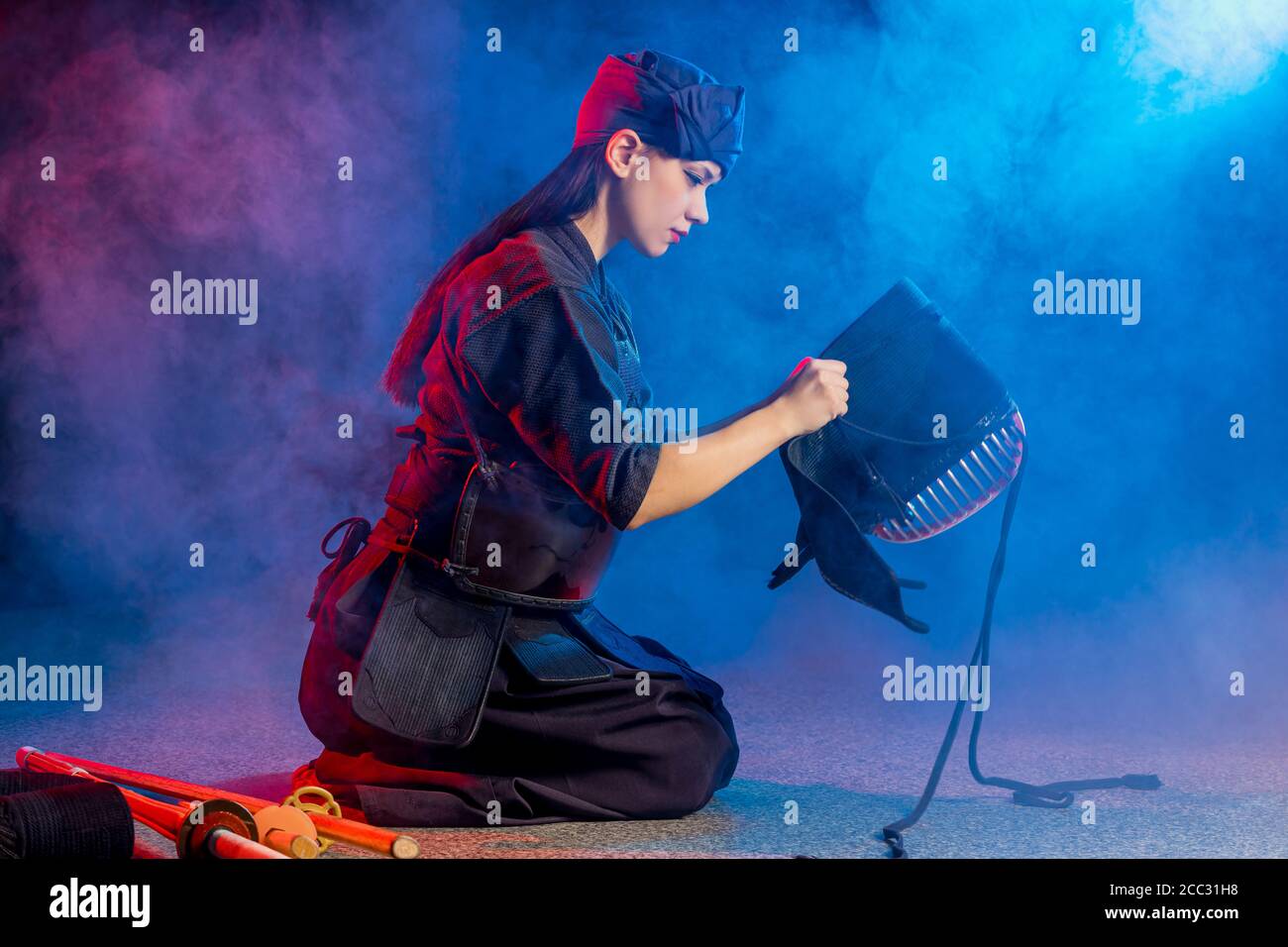 cuacasian kendo female wearing protective helmet on head before practicing fight. traditional japanese martial arts concept Stock Photo