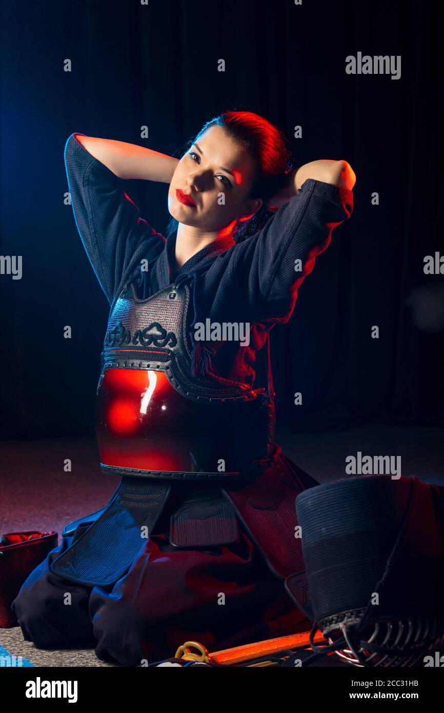 caucasian kendo fighter sit on the floor before fighting, wearing special kendo dress and using all equipment, bamboo sword shinai. japanese martial a Stock Photo