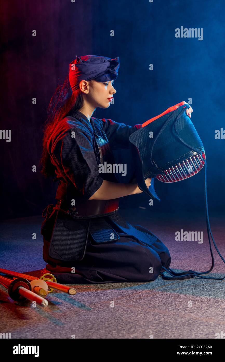 caucasian kendo fighter sit on the floor before fighting, wearing special kendo dress and using all equipment, bamboo sword shinai. japanese martial a Stock Photo