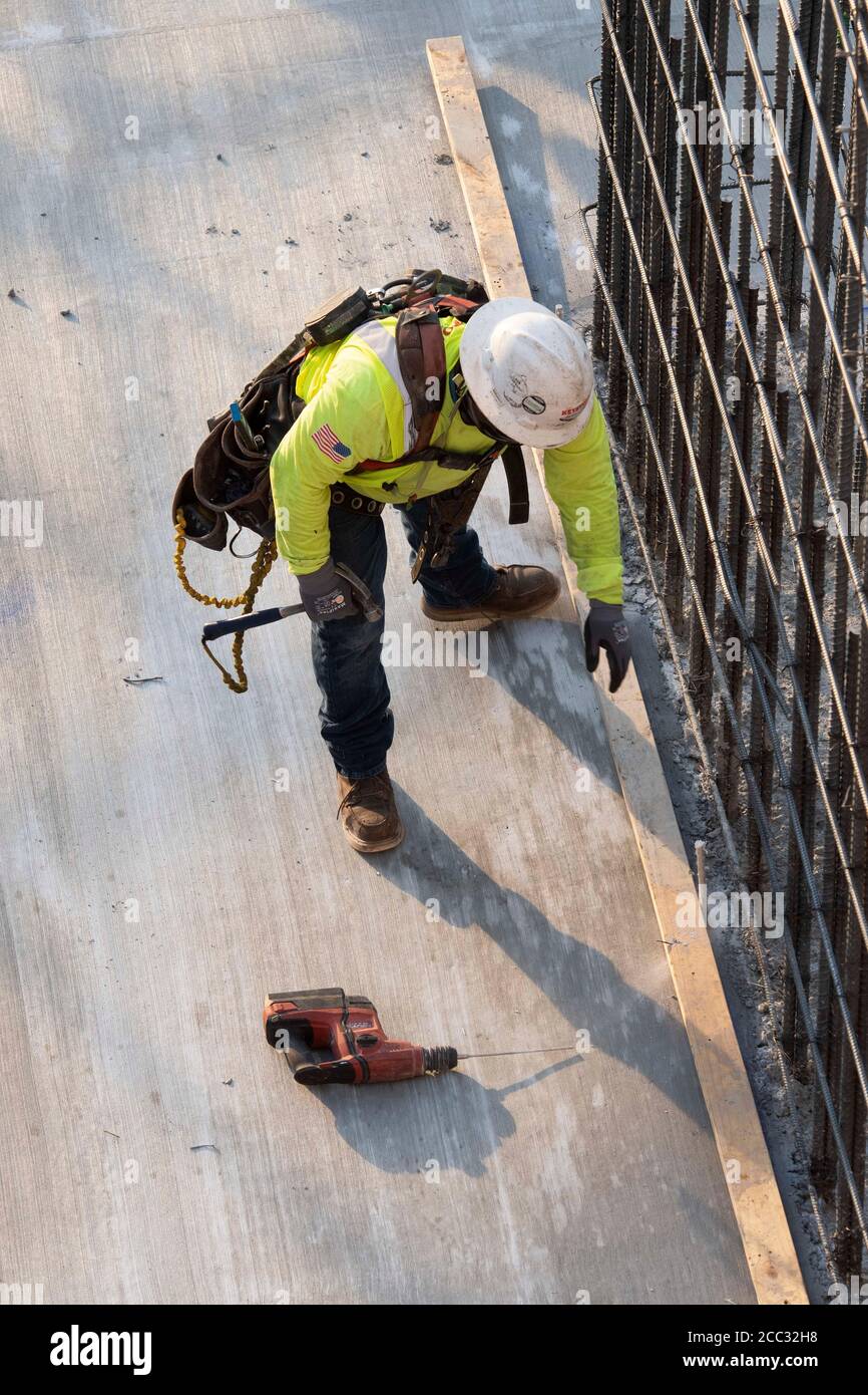 Construction worker wearing safety gear and face covering on job site