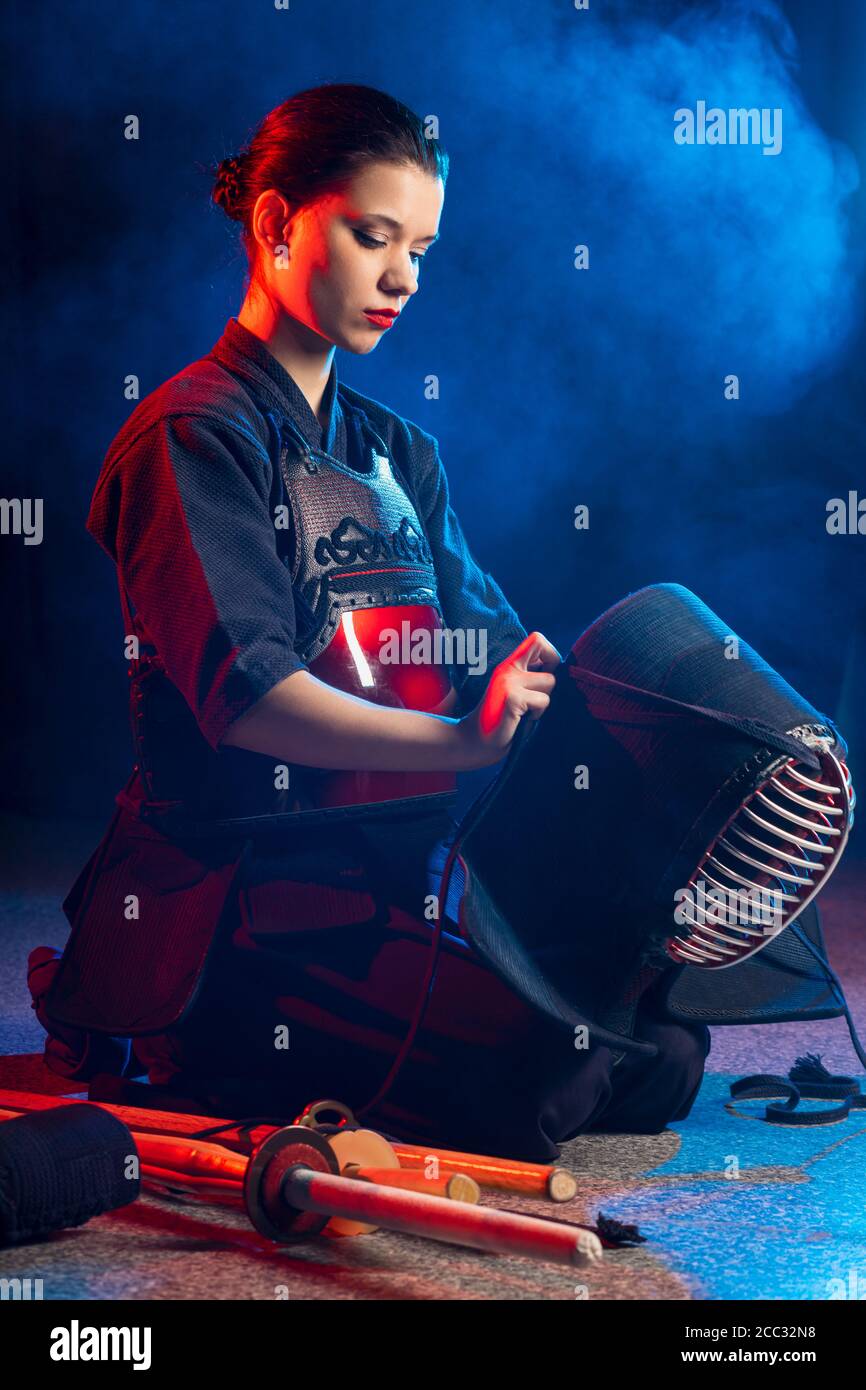 cuacasian kendo female wearing protective helmet on head before practicing fight. traditional japanese martial arts concept Stock Photo