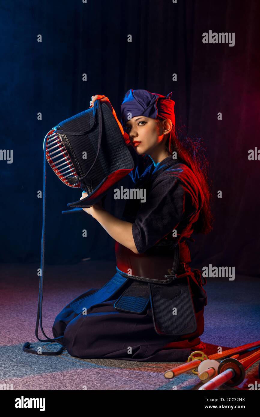 cuacasian kendo female wearing protective helmet on head before practicing fight. traditional japanese martial arts concept Stock Photo