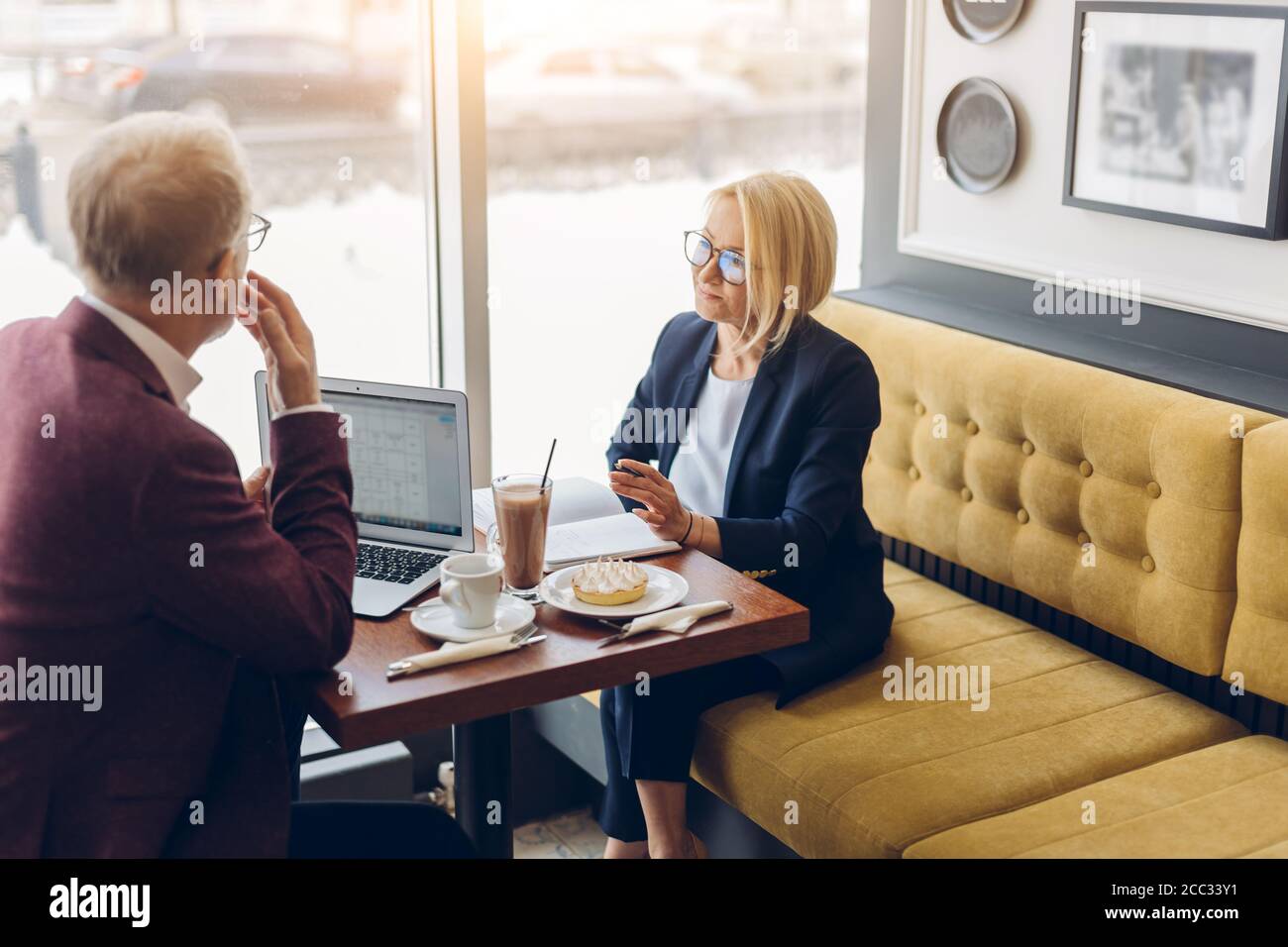 Two Clever People Brainstorming At Cafe Developing Business Strategy Using Laptop Looking Concentrated Stock Photo Alamy