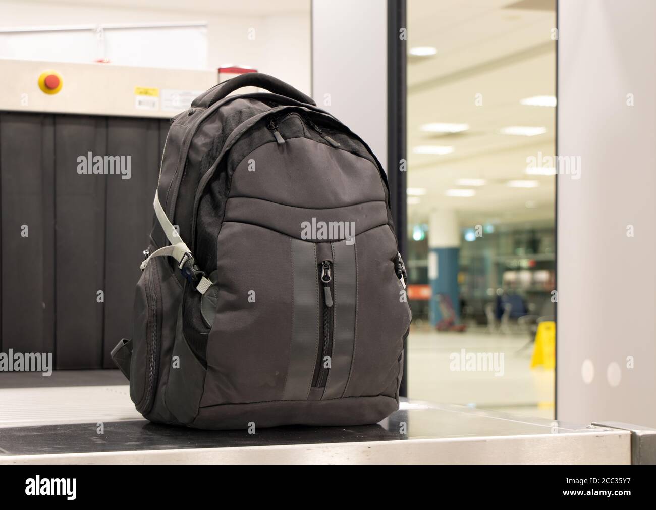 Backpack standing in front of luggage scanner at airport terminal. Baggage at checkpoint at departure gate. Stock Photo