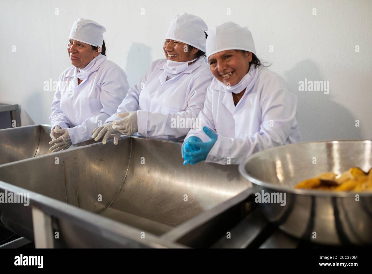 Women workers in uniform prepare to work at a banana jam processing