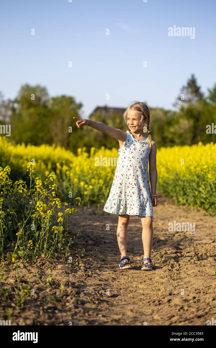 Girl standing in a rapeseed field hi-res stock photography and images ...