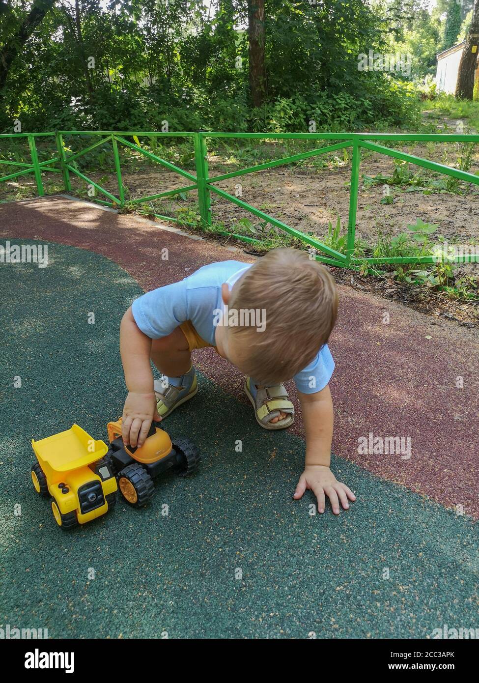 Little boy playing with toy car on playground Stock Photo - Alamy