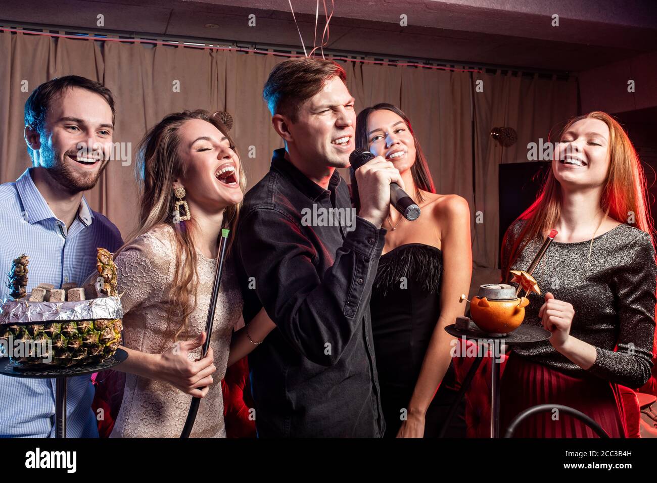 young ladies and guys chilling and rocking in karaoke bar, spend day