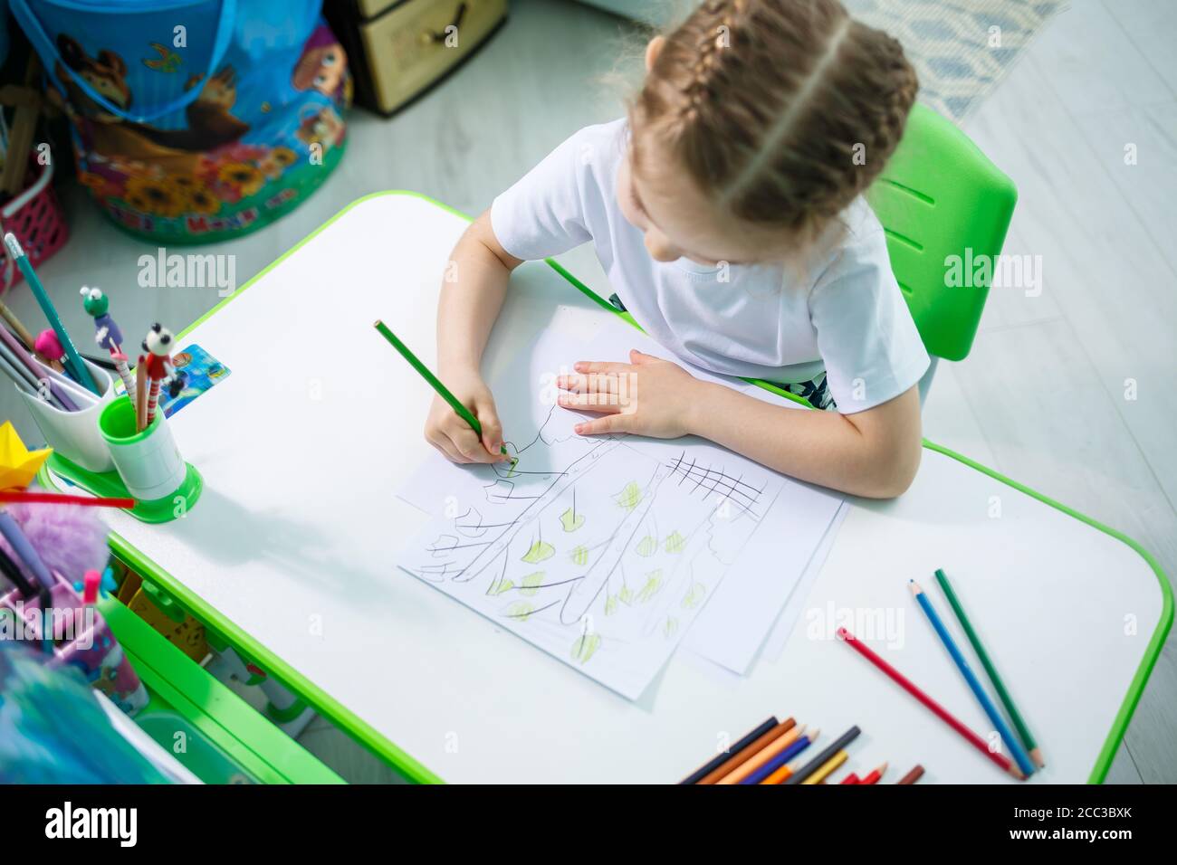Portrait of a cute little girl looking at the camera and smiling while ...
