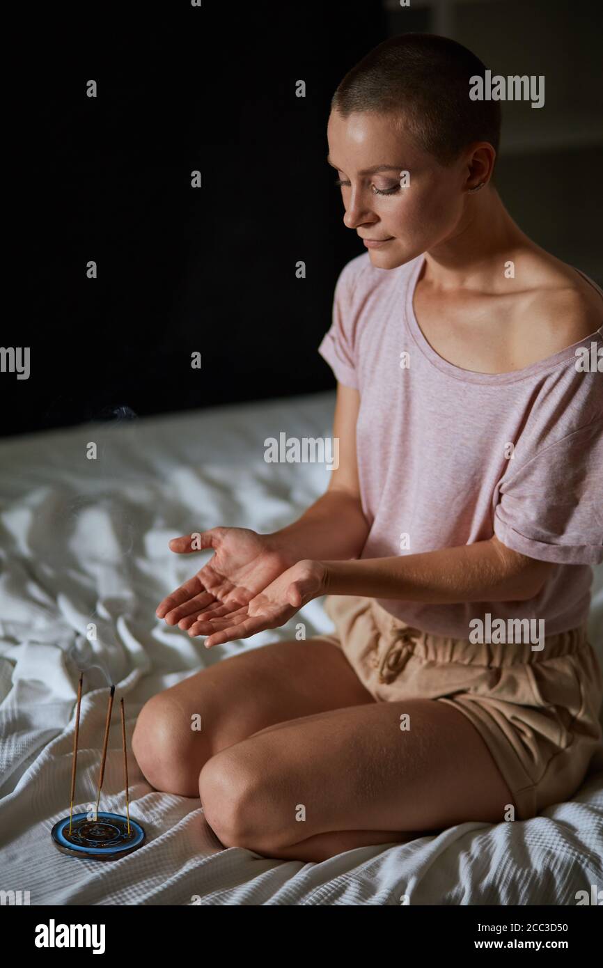Yoga meditation at home. Concentrated model near candles, keep calm and ...