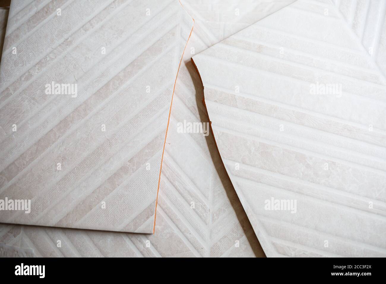 Pile of ceramic tiles in the bathroom, indoor walls. Conceptual repair in apartments, tile laying, repair inside. A pile of broken ceramic tiles remai Stock Photo