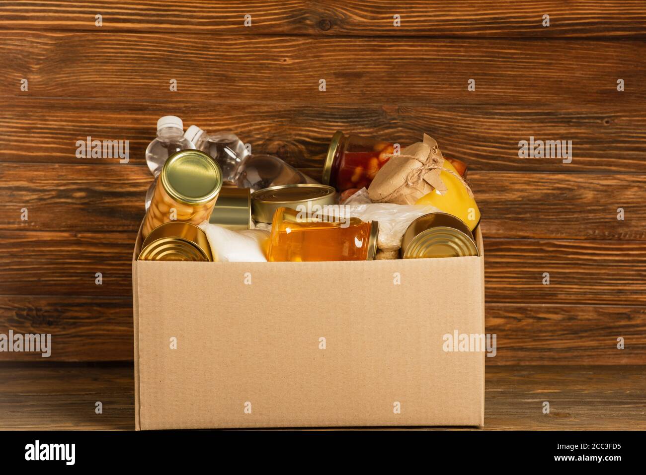 cardboard box with donated food on wooden background, charity concept ...