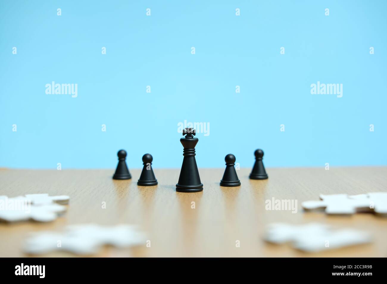 Business strategy conceptual photo - king and chess pawn in line, standing in front of jigsaw puzzle Stock Photo