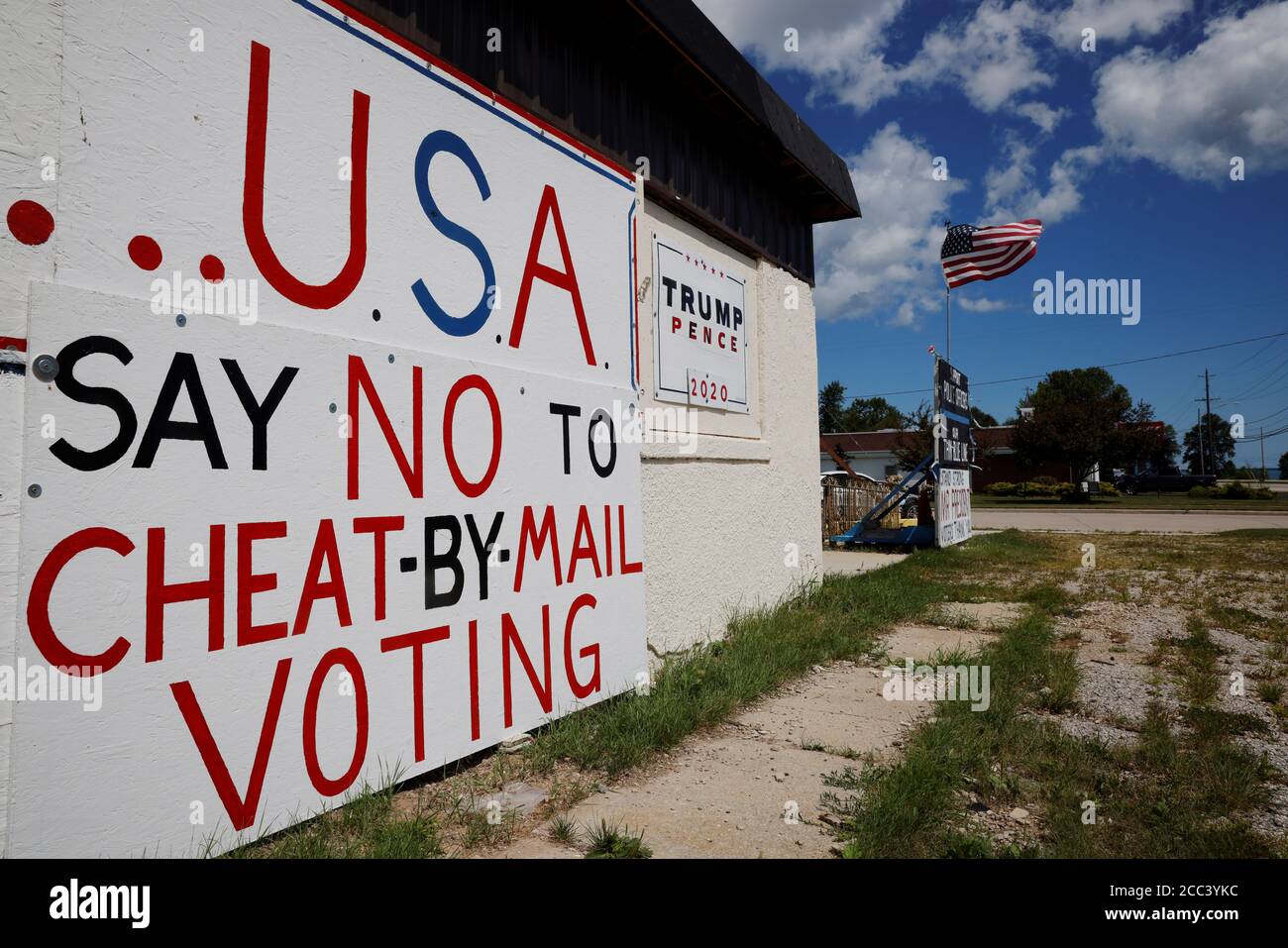 Handmade signs supporting U.S. President Donald Trump, including one opposing mail-in voting, stand outside a business in Manitowoc, Wisconsin, U.S., August 18, 2020. REUTERS/Brian Snyder Stock Photo