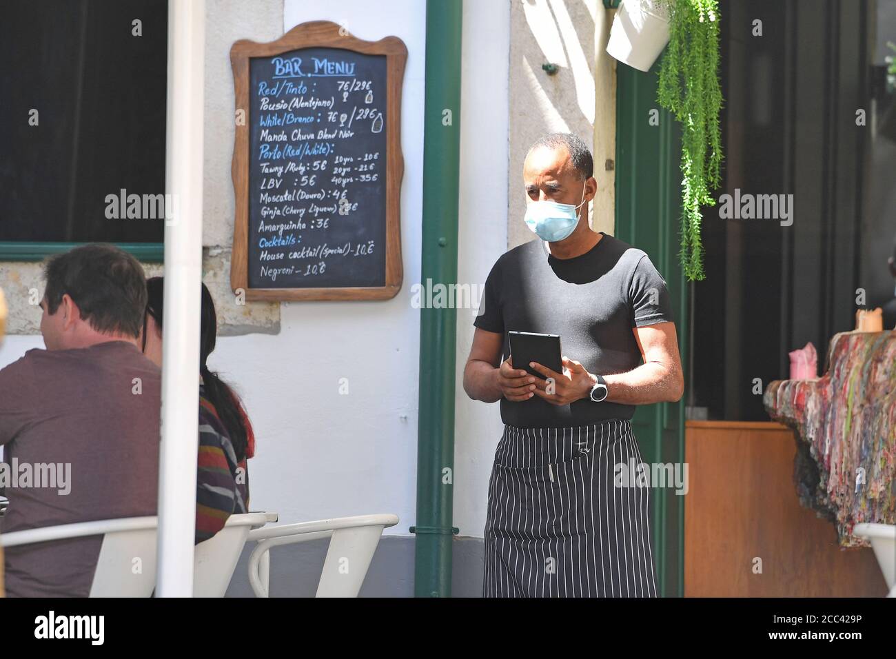 Lisbon, Portugal. 16th Aug, 2020. A waiter with face mask, mask waits for guests in front of the